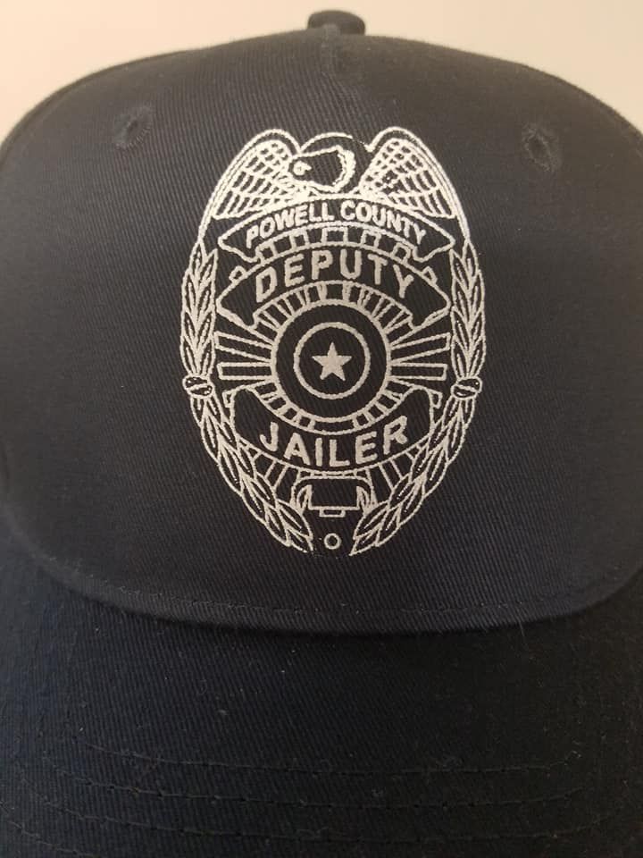 A black hat with a jailer badge on it