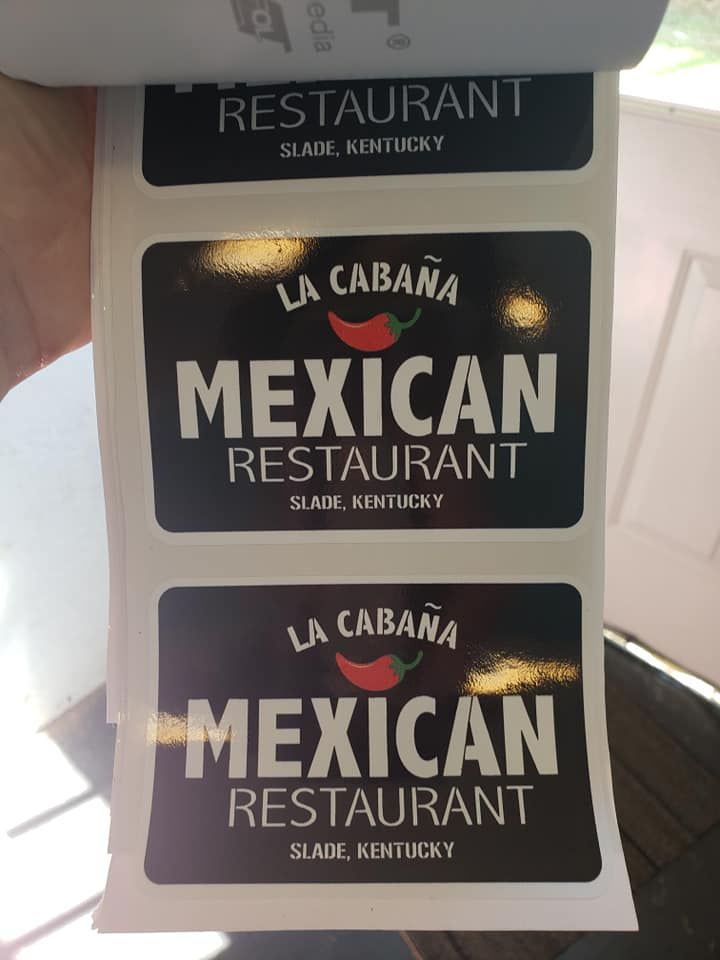 A person is holding a roll of mexican restaurant stickers
