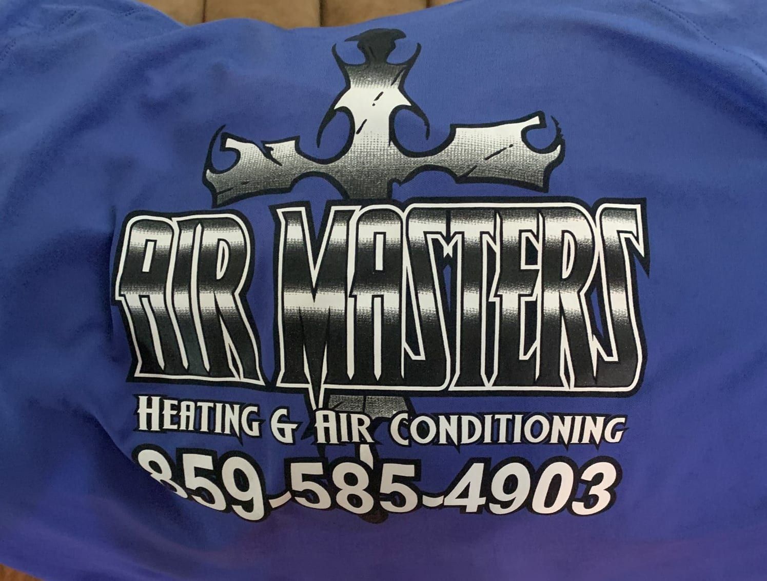 A blue shirt that says air masters heating and air conditioning
