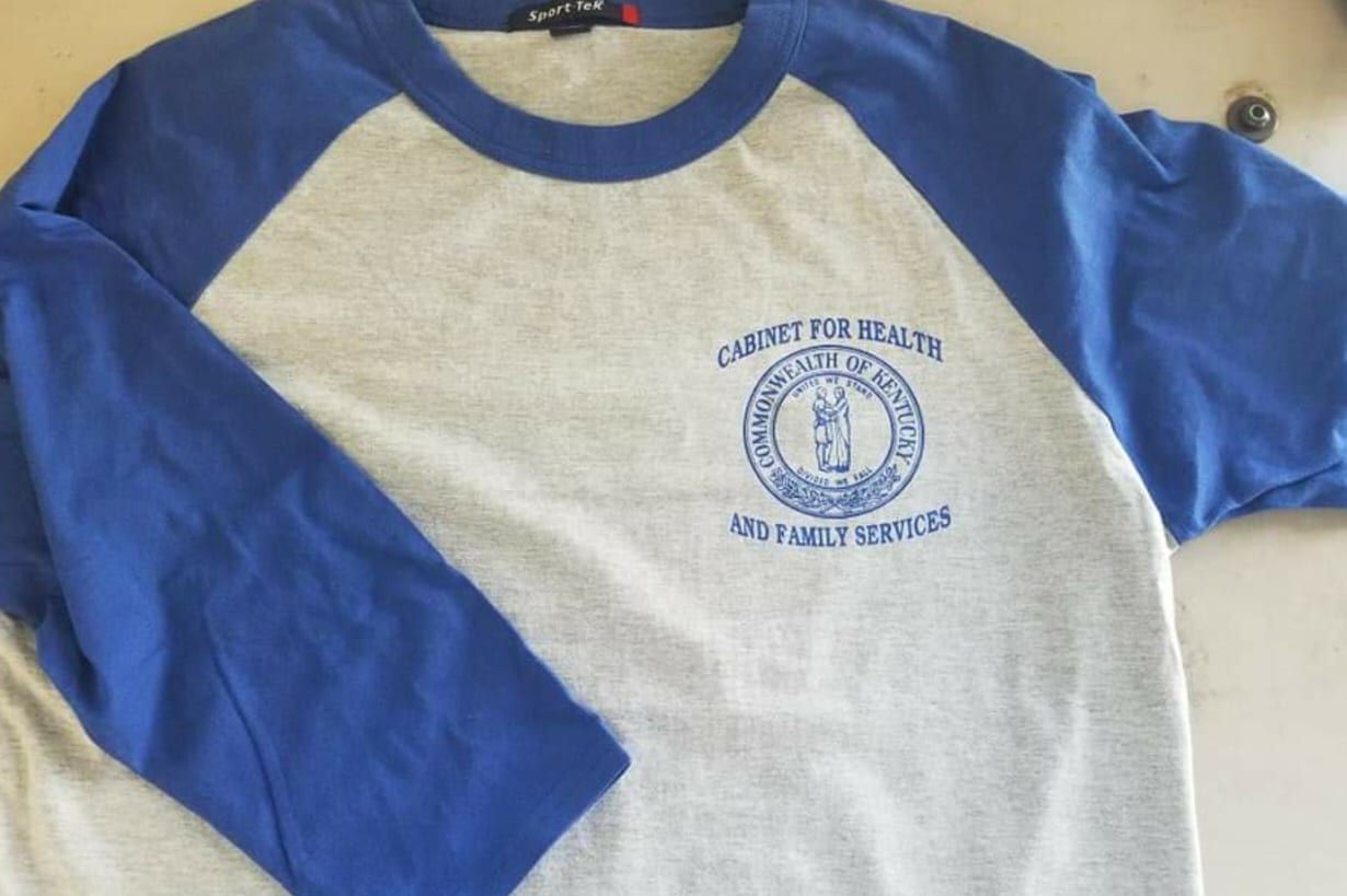 A blue and white baseball t-shirt with the word county on it