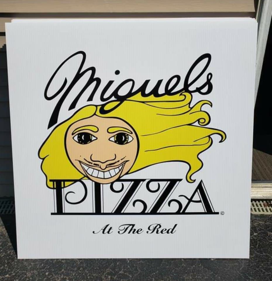 A sign for miguel 's pizza at the red