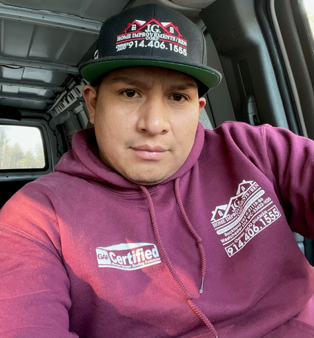 A man wearing a purple hoodie and a hat that says certified