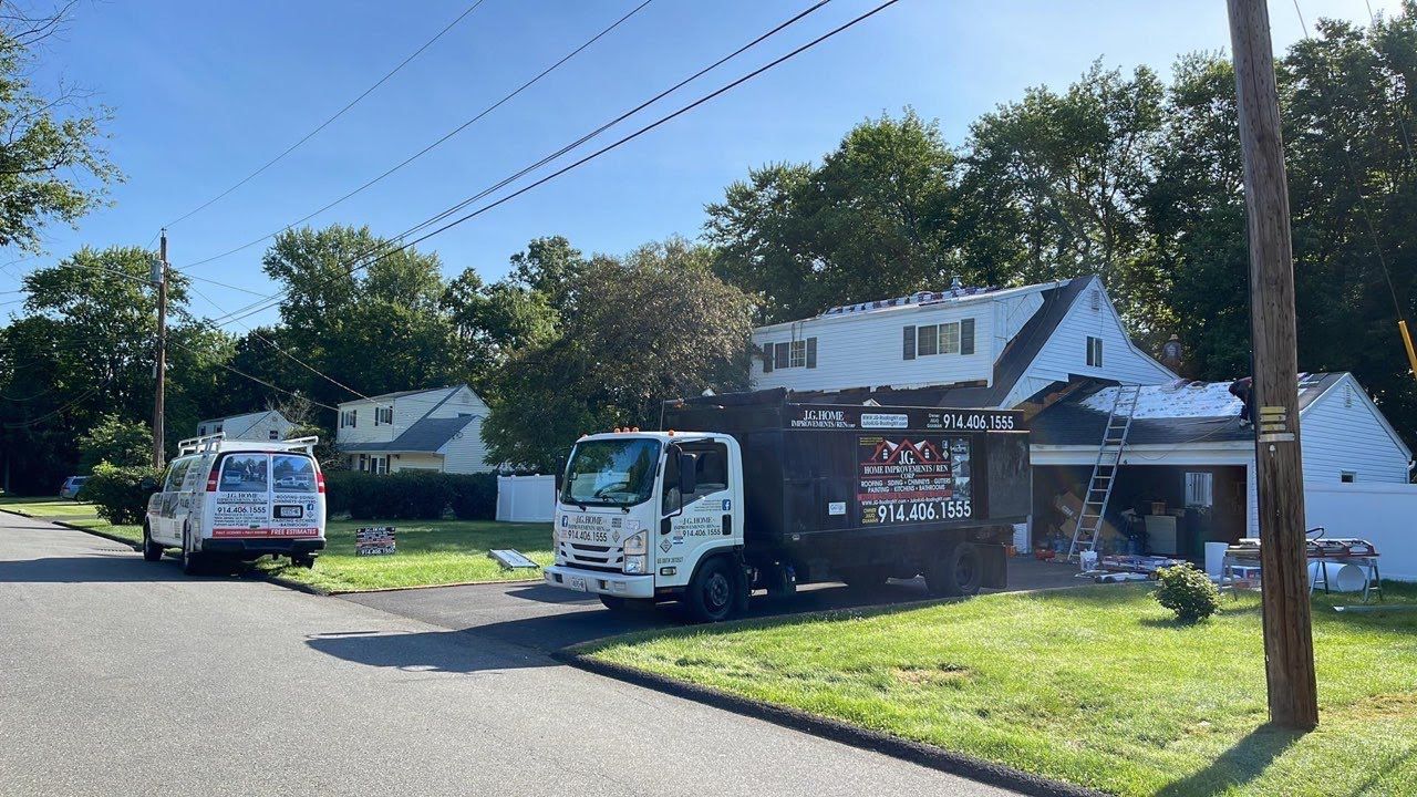 A truck is parked in front of a house that is being painted.