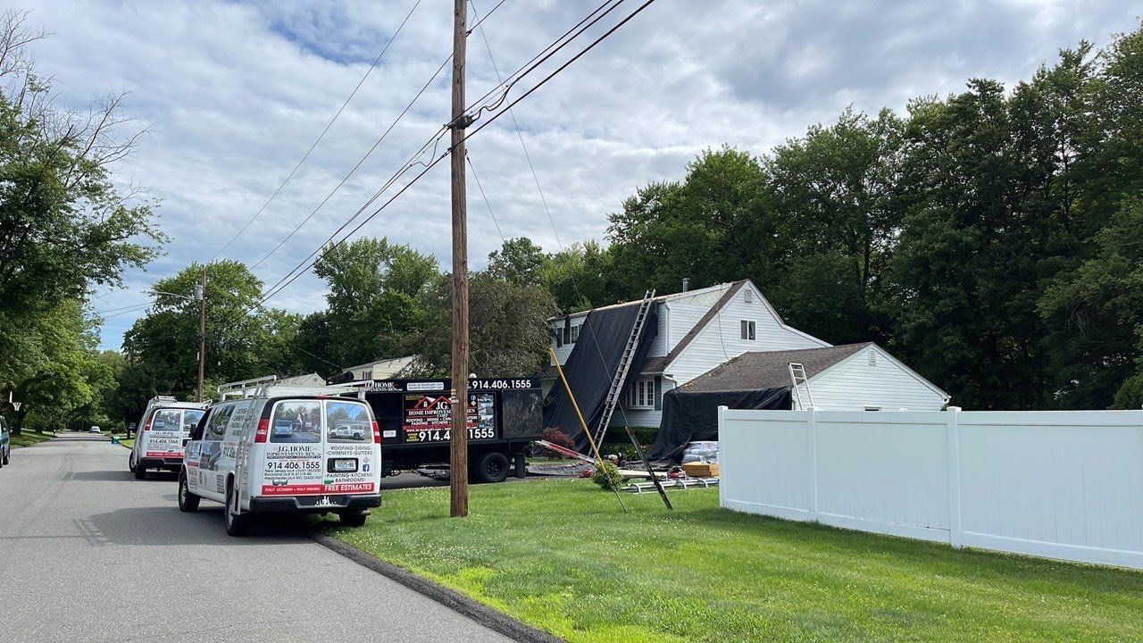 A white van is parked on the side of the road next to a house.