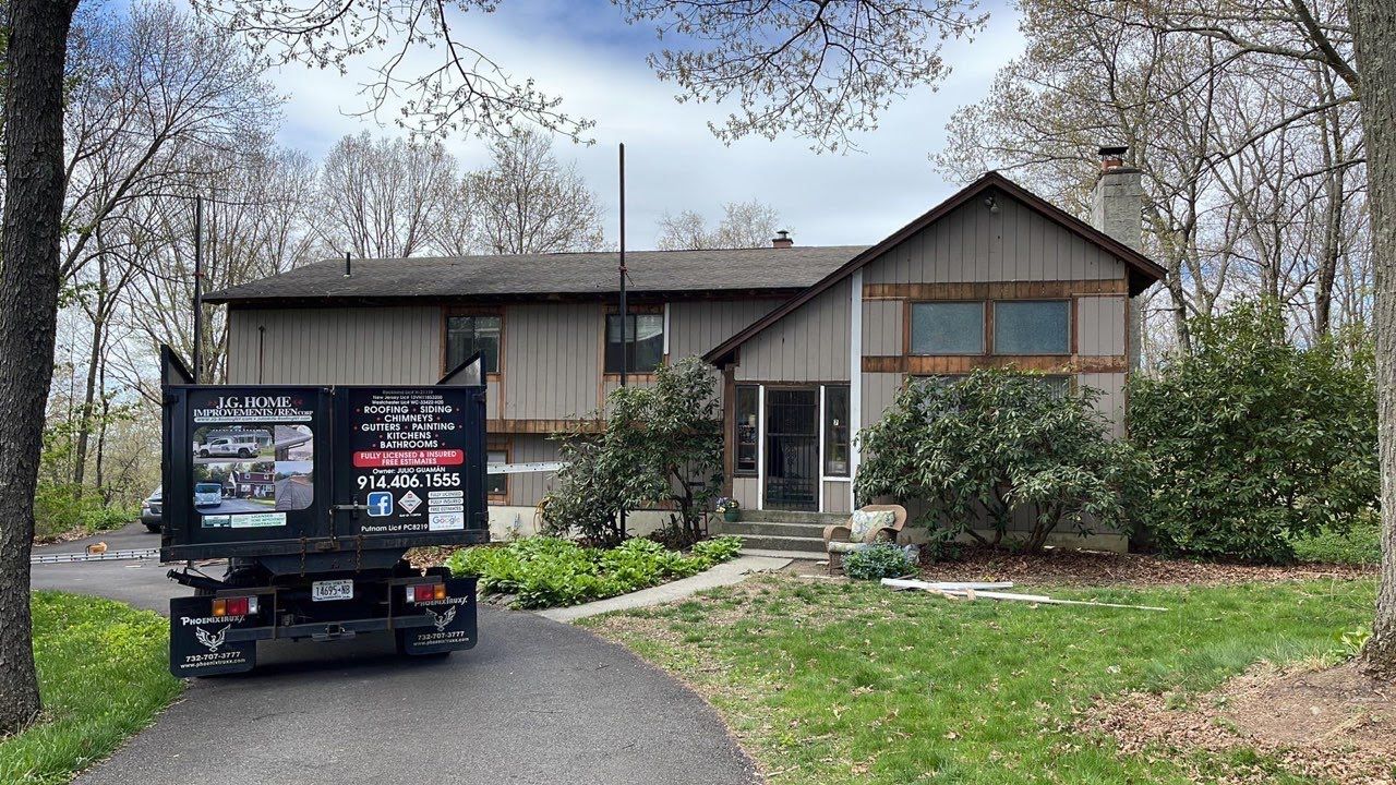 A dumpster is parked in front of a house.