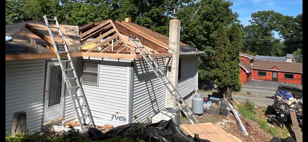 A house is being remodeled with a ladder on the side of it.