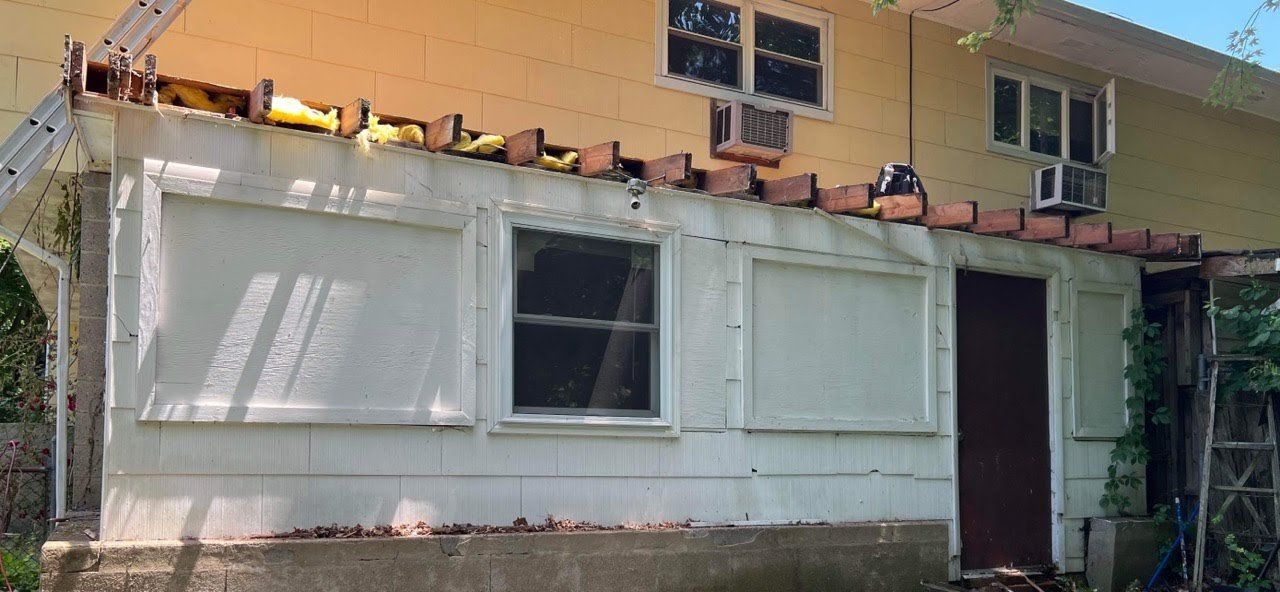 A house with a ladder hanging from the side of it.