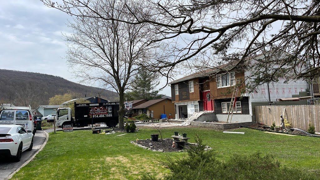 A house with a lot of cars parked in front of it.