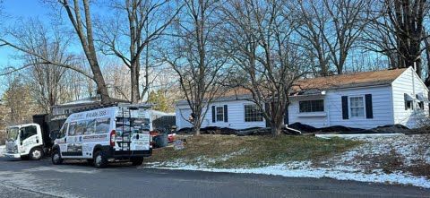 A white van is parked in front of a house.