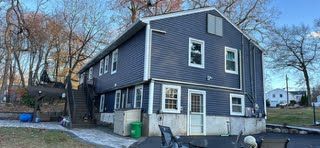 A large house with a lot of windows and a patio in front of it.