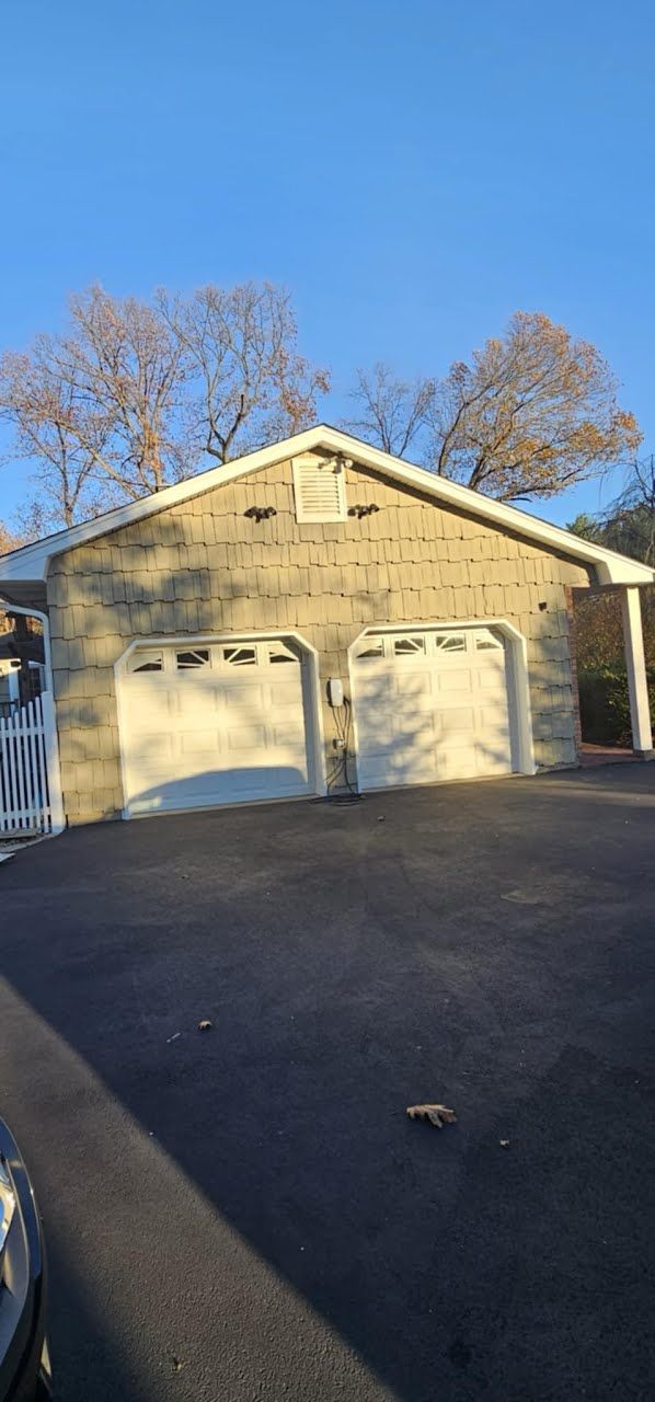 A garage with two garage doors and a car parked in front of it.