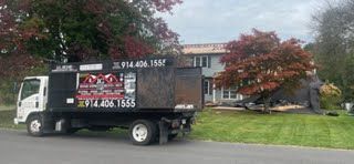 A dump truck is parked in front of a house.