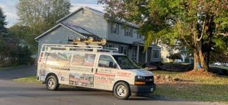 A white van is parked in front of a house.