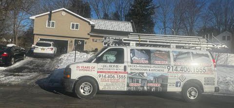 A van is parked in front of a house in the snow.