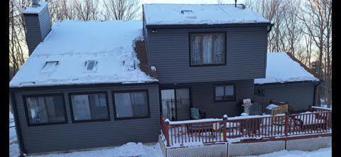 A large house with a lot of windows and a snowy roof.