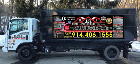 A white truck with a large billboard on the side is parked on the side of the road.