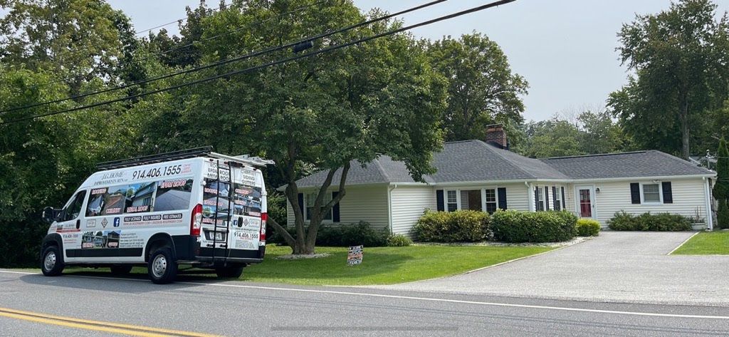 A white van is parked in front of a white house