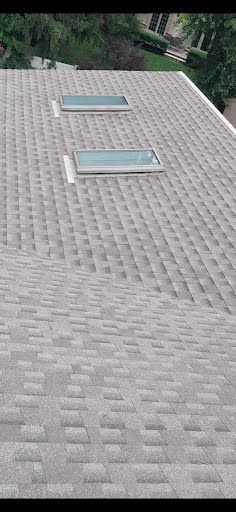 A roof with three skylights on it.