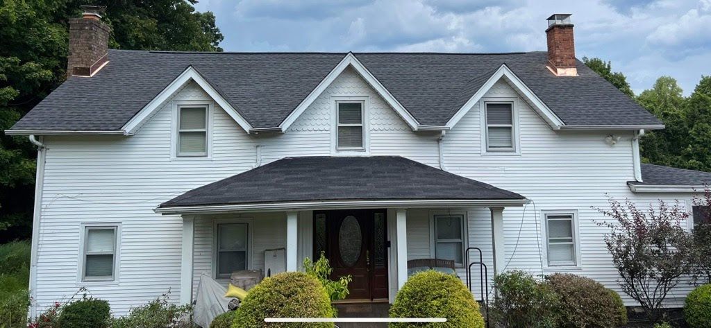 A white house with a gray roof and a chimney