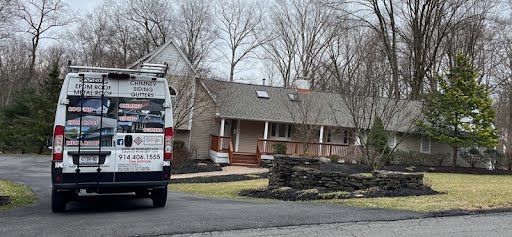 A white van is parked in front of a house.