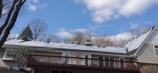 A house with a balcony and a roof that is covered in snow.