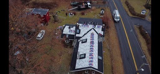 An aerial view of a house in the middle of a field next to a road.