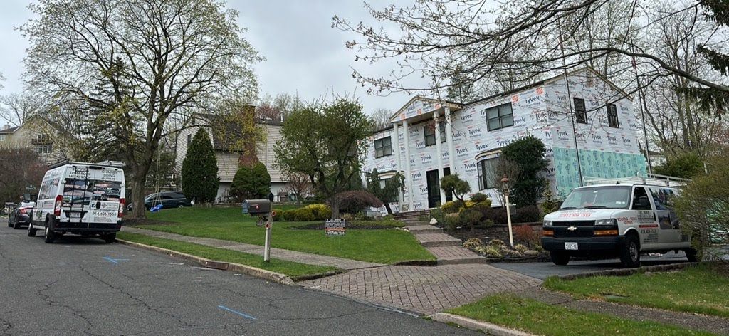 A white van is parked in front of a white house.