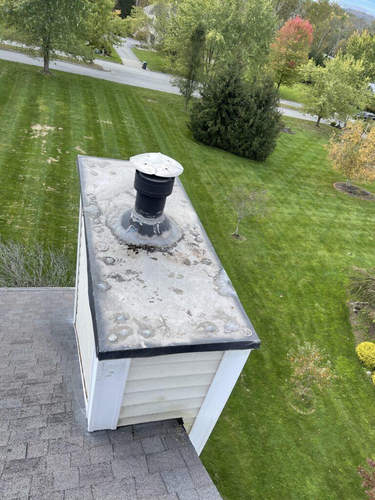 An aerial view of a chimney on the roof of a house.