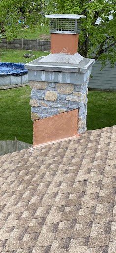 A chimney is sitting on top of a roof next to a pool.
