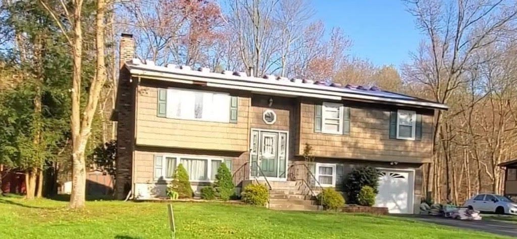 A house with a lot of windows and a car parked in front of it.