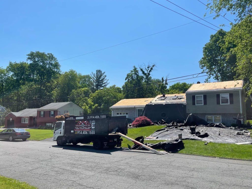 A truck with the word ace on it is parked in front of a house.