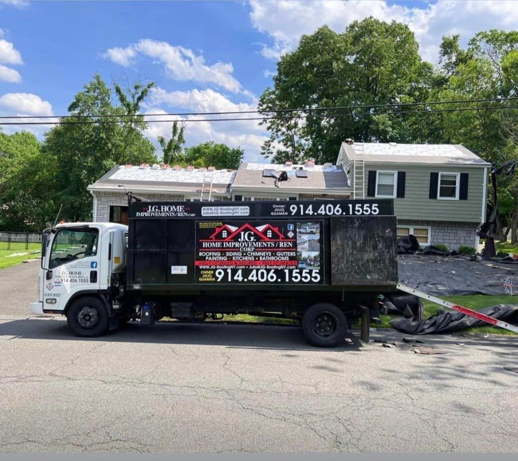 A roofing truck is parked in front of a house