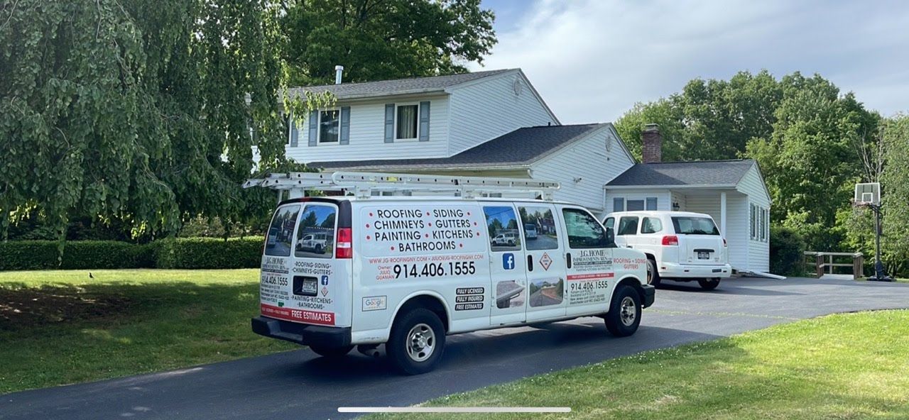 A white van is parked in front of a white house.