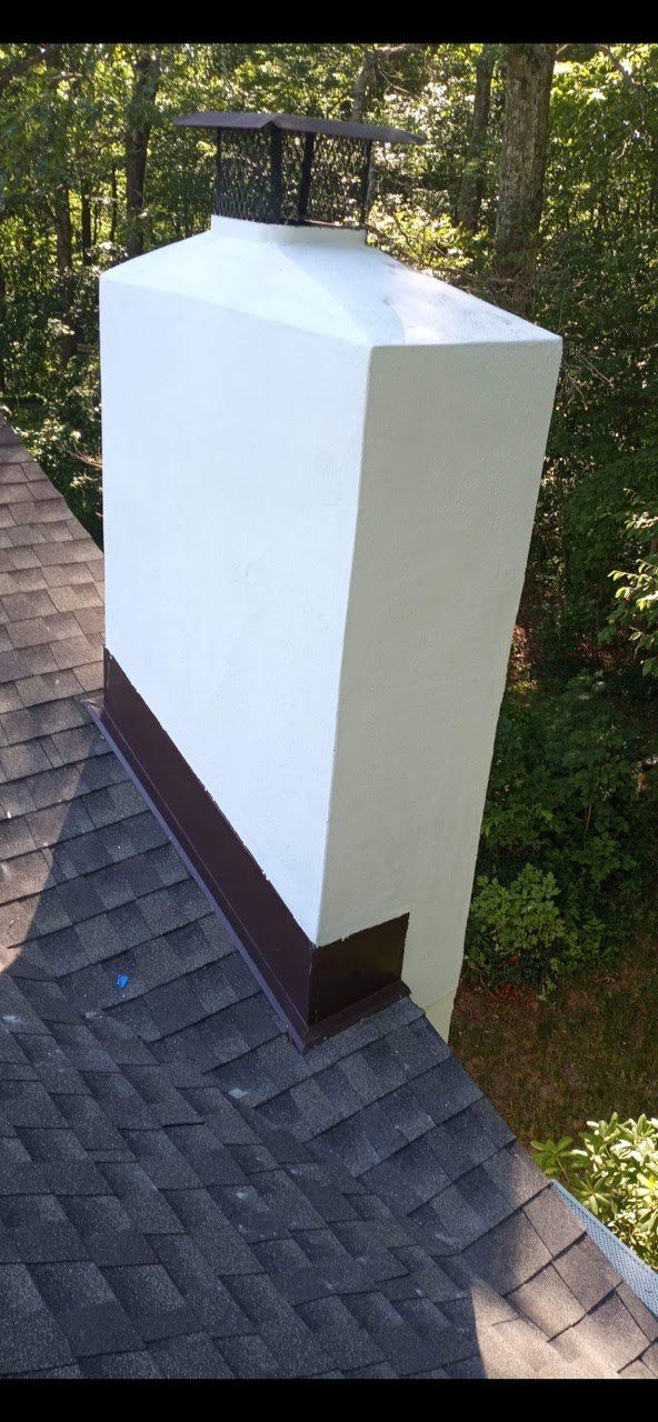 A white chimney is sitting on top of a roof.