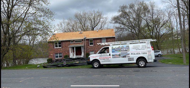 A white van is parked in front of a brick house.