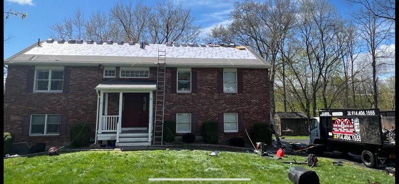 A brick house with a roof that is being installed.