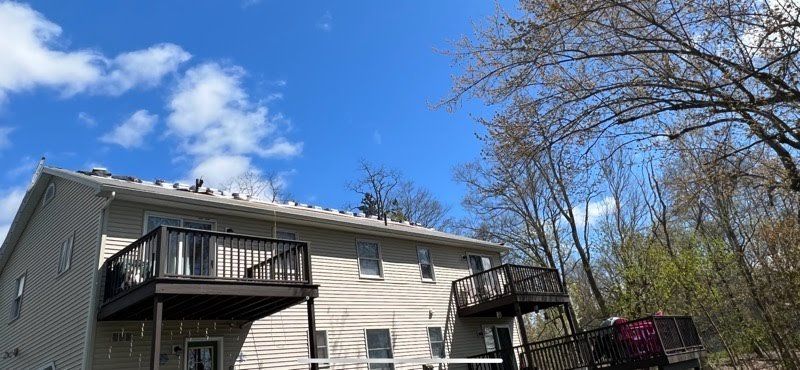 A house with two decks and a blue sky in the background.