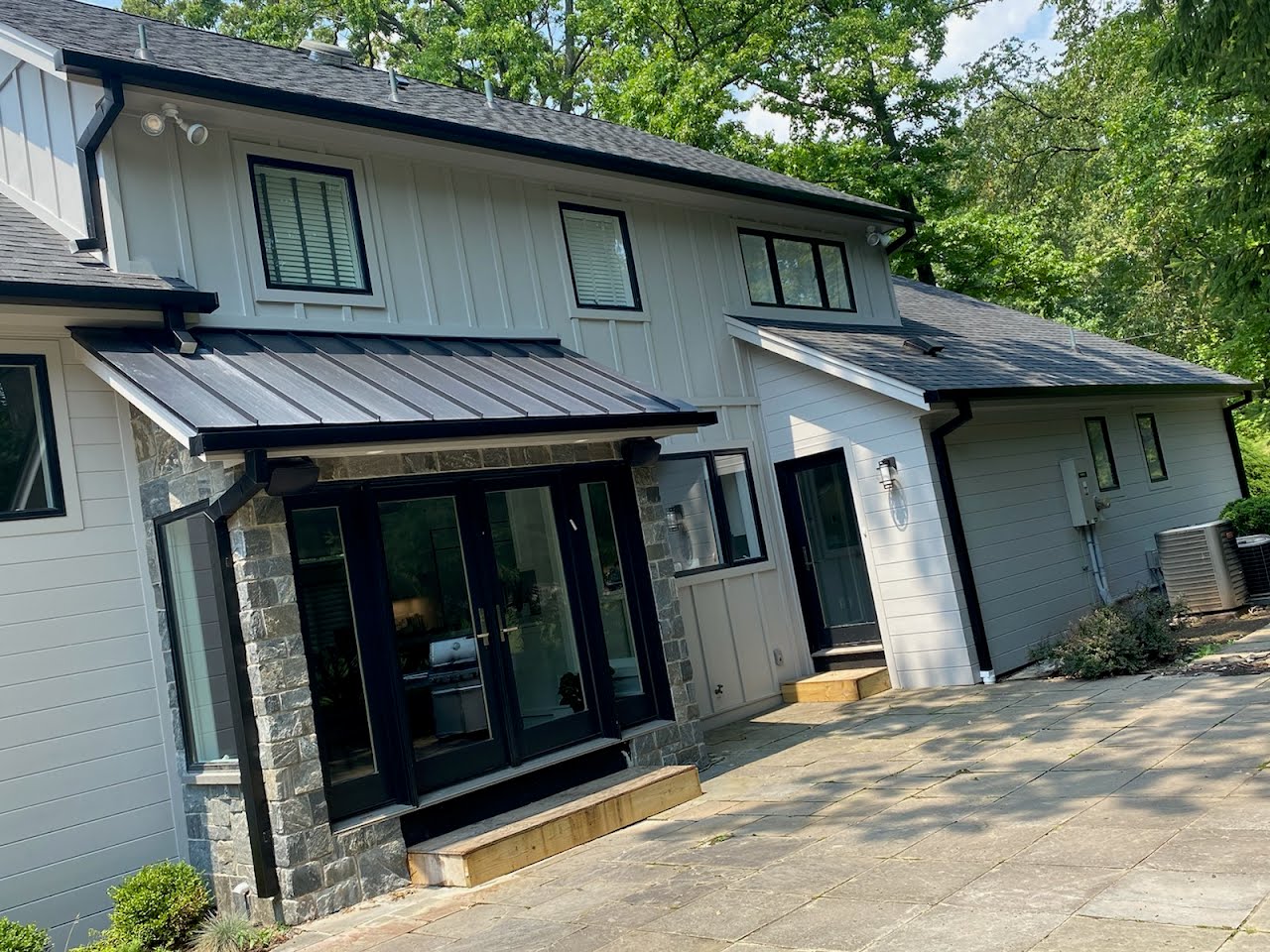 A white house with a black roof and a black door.