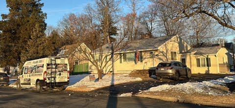 A white van is parked in front of a house.