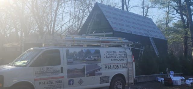 A white van is parked in front of a house under construction.