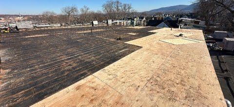 A roof with a lot of plywood on it is being built.