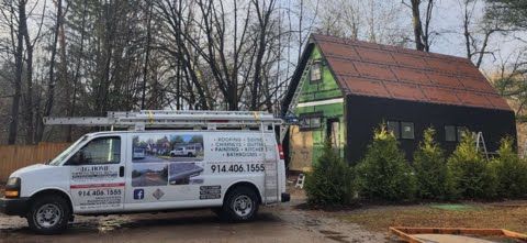 A white van is parked in front of a house.