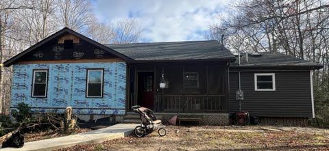 A house with a stroller parked in front of it is being remodeled.