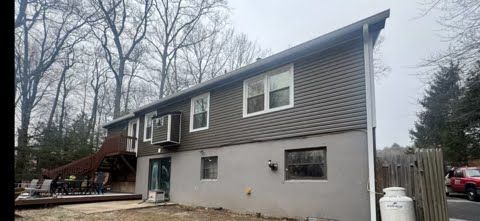 A large house with a lot of windows is sitting in the middle of a forest.