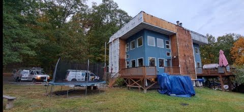 A large blue house with a trampoline in front of it.