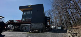 A large black building with a jeep parked in front of it.