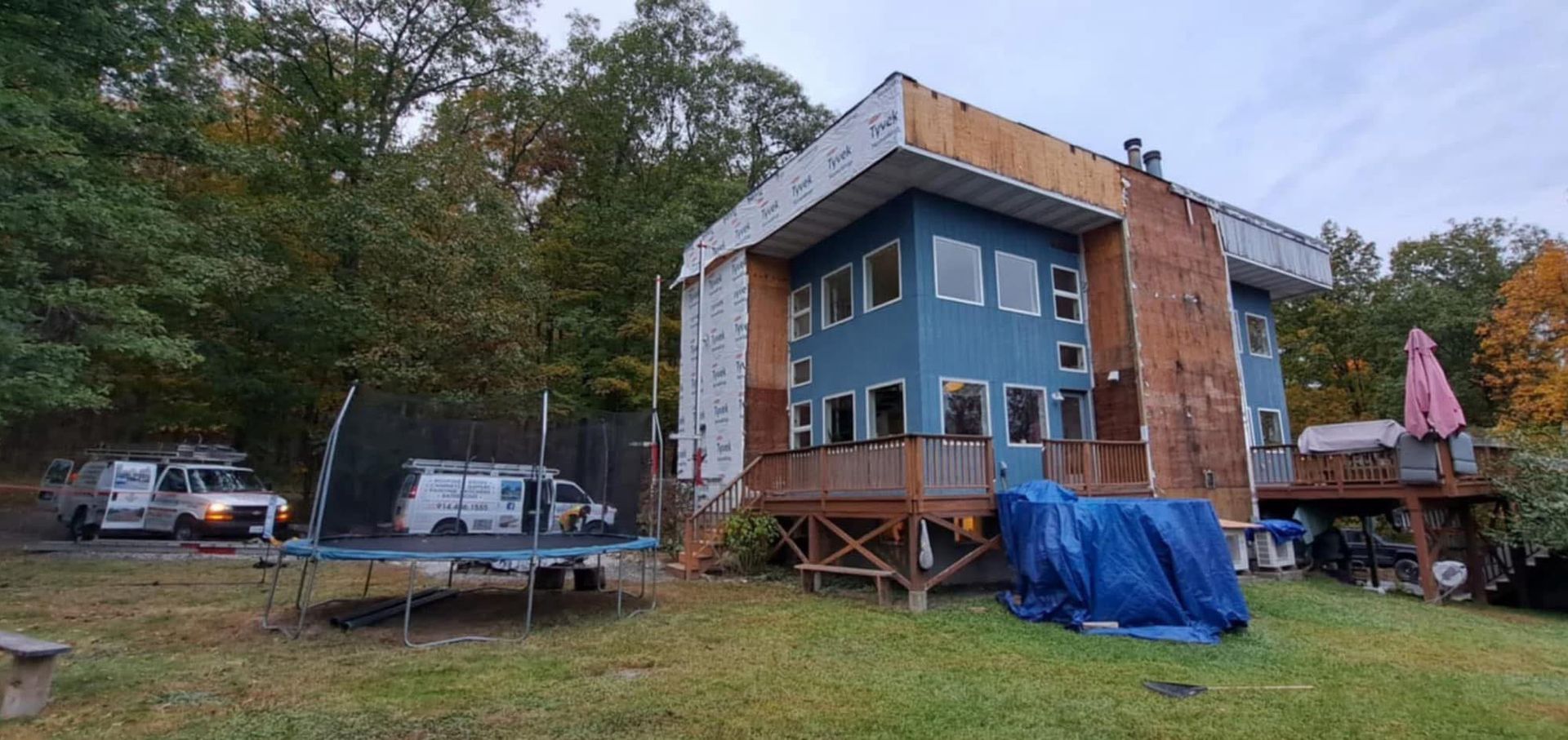 A large blue house with a trampoline in front of it.