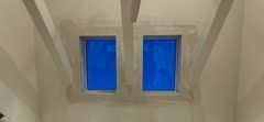 There are two blue windows in the ceiling of a room.