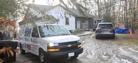 A white van is parked in front of a house.