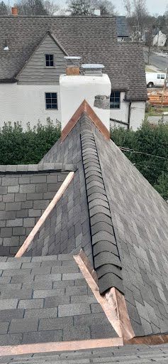 A close up of a roof with a copper gutter on it.